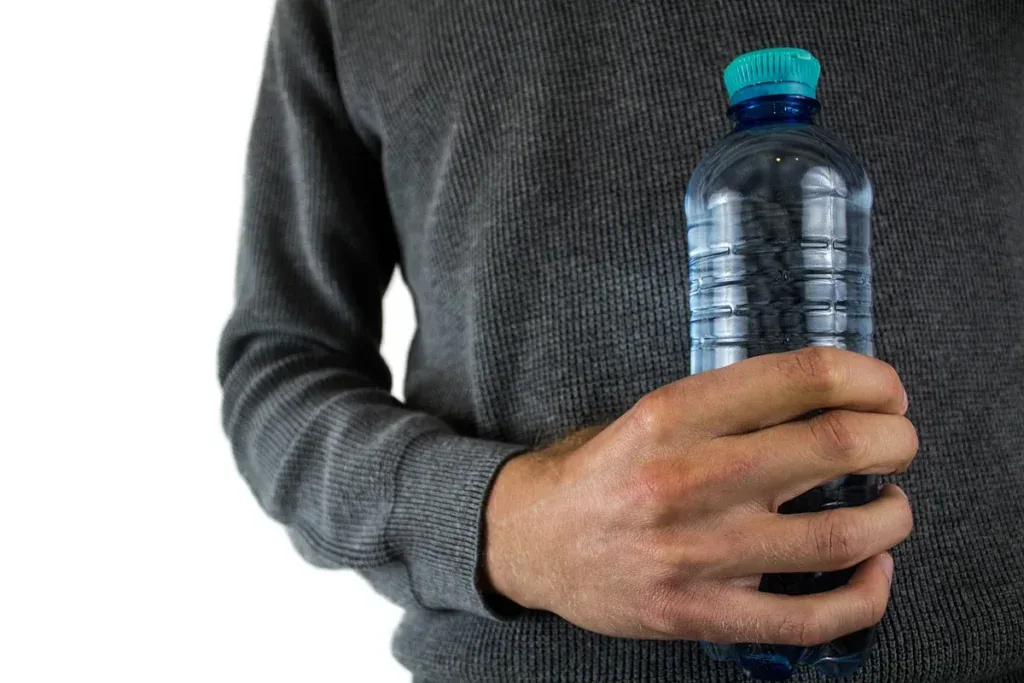 Plastikowa butelka wody w dłoni – ile kosztuje litr wody z butelki w porównaniu z kranówką