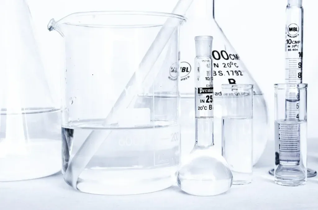 Laboratoryjne zlewki i cylindry miarowe z wodą, przy których przydaje się przelicznik jednostek twardości
